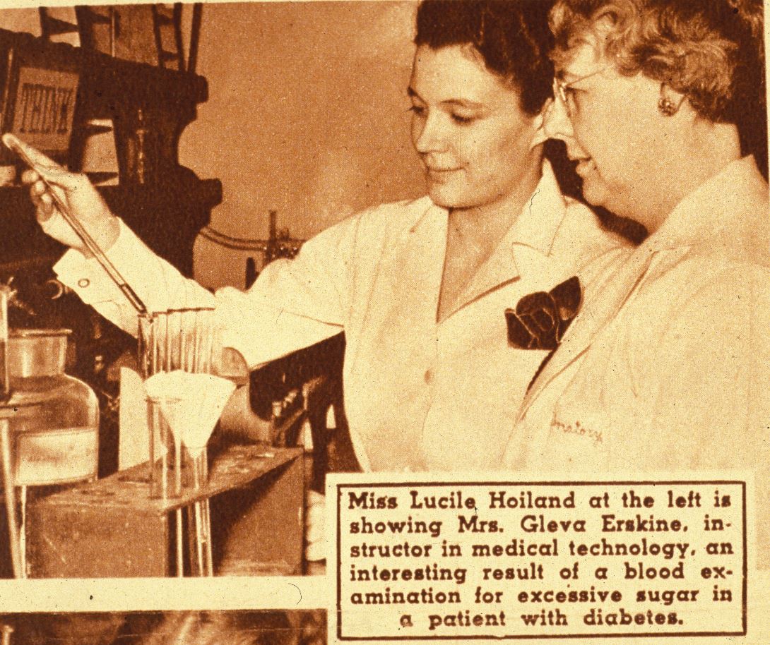 Miss Lucile Hoiland at the left showing Mrs. Gleva Erskine a blood examination result