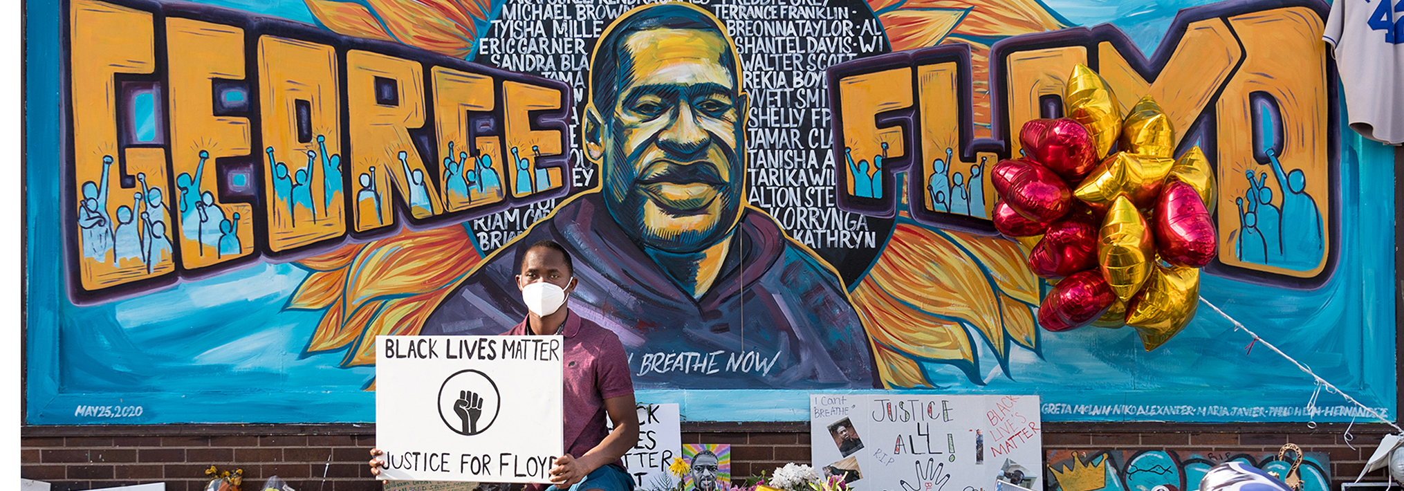 George Floyd Mural Cropped with a man holding a banner