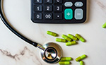 stethoscope, pill capsules, and calulator on a table